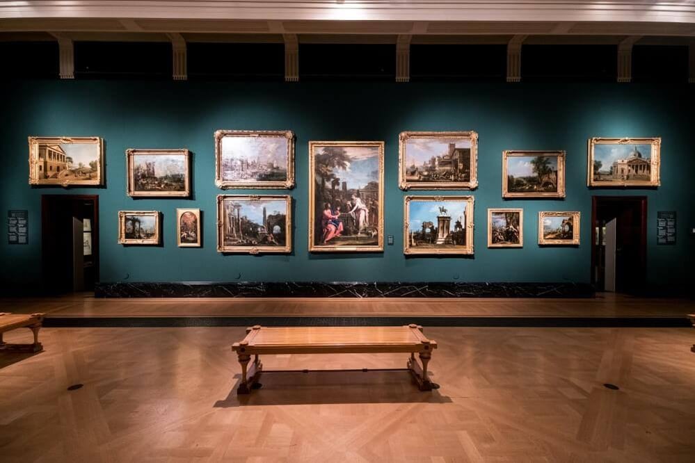 A bench and paintings in a museum