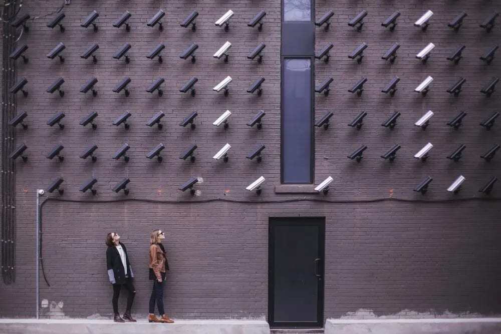 Two people looking up at dozens of cameras