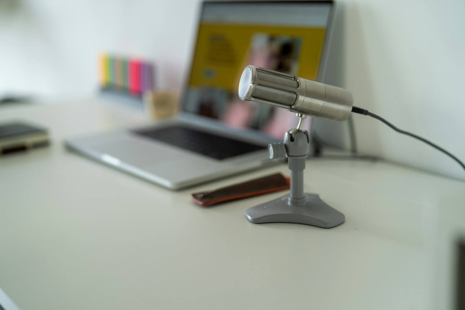 a USB mic on a table next to a laptop