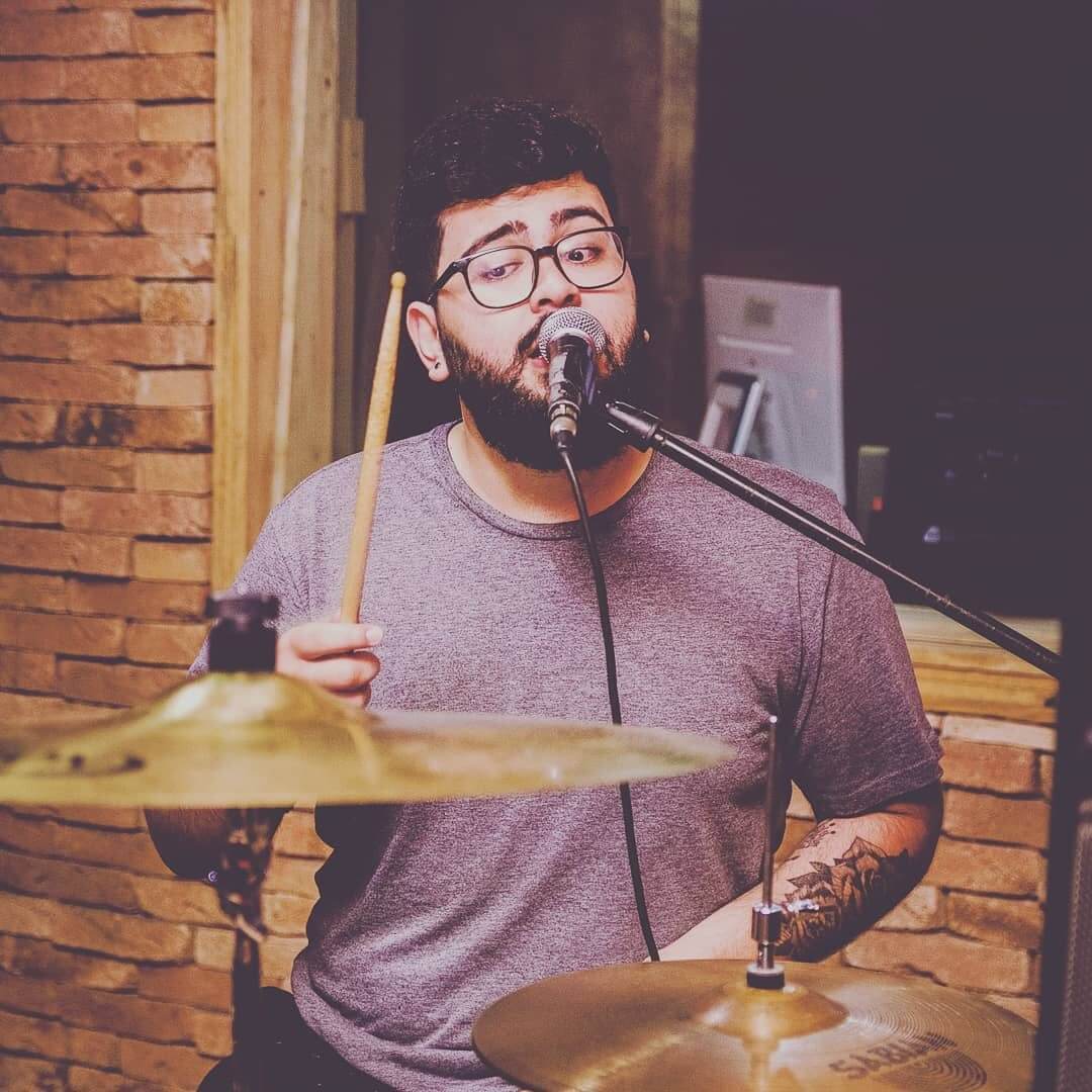 Davi playing the drums while singing