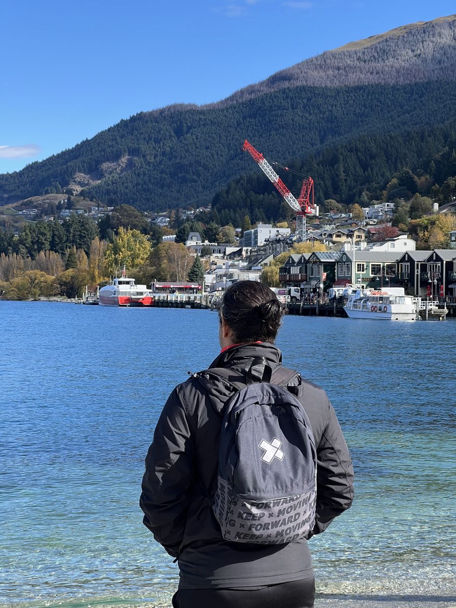 An X-Teamer with an X-Team backpack overlooking the lake at Queenstown