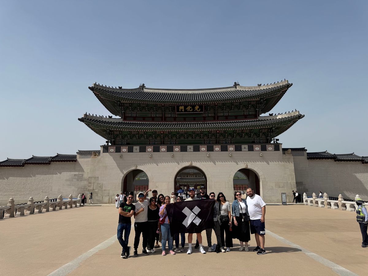 X-Teamers gathered with the X-Team flag at Gyeongbokgung Palace in Seoul