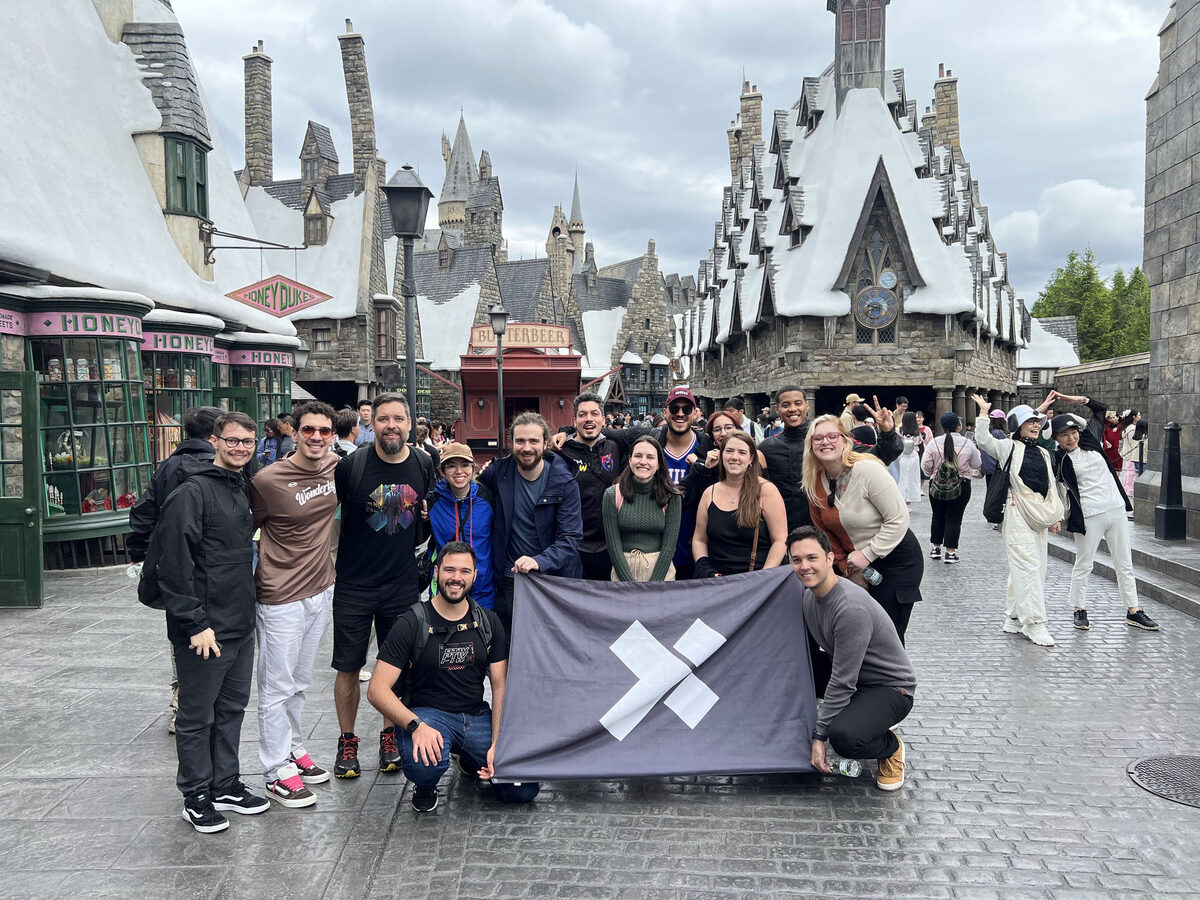A group of X-Teamers holding the X-Team flag at the Wizarding World of Harry Potter during an X-Outpost
